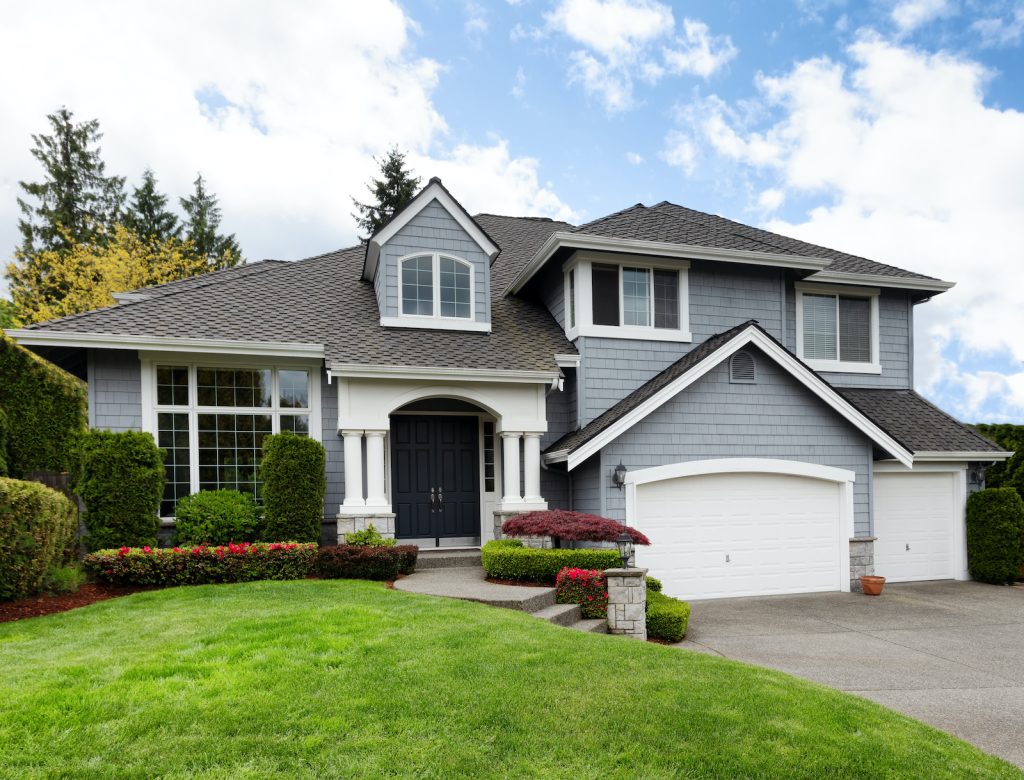 A modern two-story house with a well-kept lawn and garden.