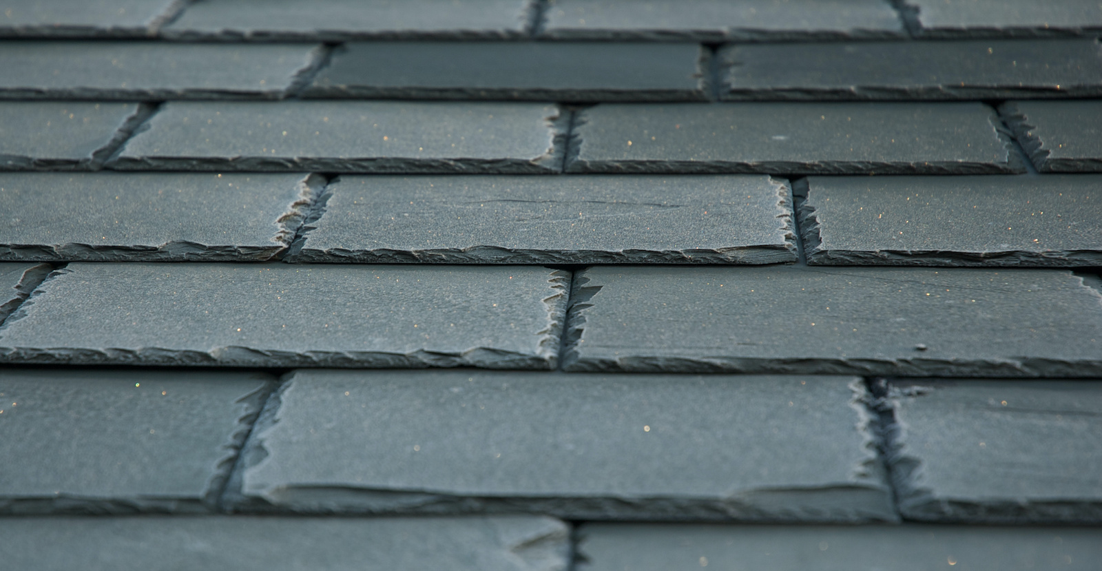 Close-up of dark gray brick wall with textured surface.