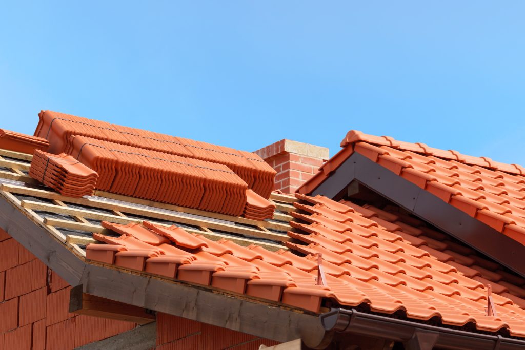 Close-up of a red tiled roof under a clear blue sky.