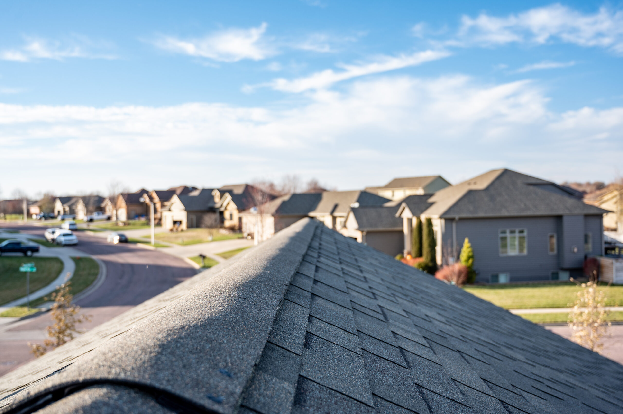 View of suburban rooftops under a partly cloudy sky.